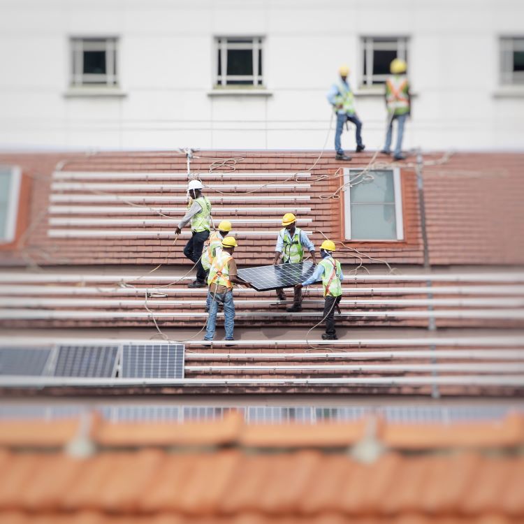 Men installing photo panels on a roof.